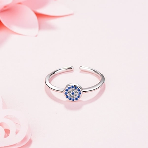 Silver adjustable evil eye ring featuring blue and white zircon stones on pink background