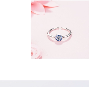 Macro shot of silver Evil Eye ring with blue and clear zircons on pink petals