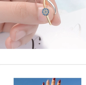 Macro shot of two-tone gold and silver ring featuring blue evil eye crystal inlay
