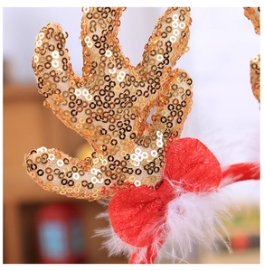 Detailed view of reindeer antlers headband with golden sequins and red velvet bow
