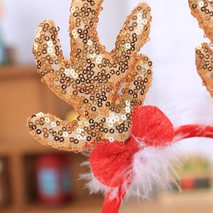 Christmas reindeer antler headband with gold sequins, red bow, and white feathers