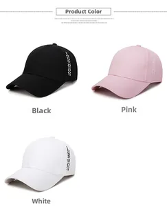 Détail des casquettes en coton noir, rose et blanc avec broderie sur le côté