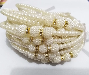 Close-up of elegant cream pearl bracelets with gold rhinestone spacers and details