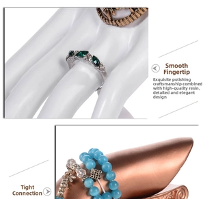 Dettaglio di un modello di mano in resina con anelli e bracciali su supporti per gioielli