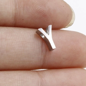 Close-up of a tiny silver Y-shaped metal charm bead for DIY jewelry making and necklaces