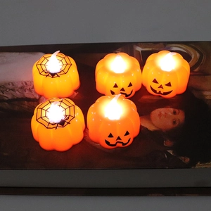 Orange Halloween LED pumpkin and spider web candles with warm yellow glowing light