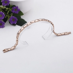 Rose gold magnetic therapy link bracelet on a display stand with a 45-degree view