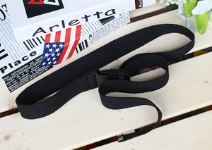 Detail of black canvas tactical belt with durable plastic buckle on a wooden background