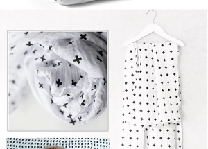 Détail d'une couverture d'emmaillotage en mousseline douce avec imprimé croix noires
