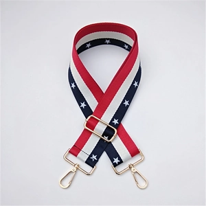 Detail of red white and blue striped woven bag strap with stars and gold metal hardware
