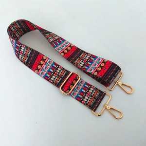 Close-up of woven ethnic strap with colorful geometric patterns and gold metal hardware