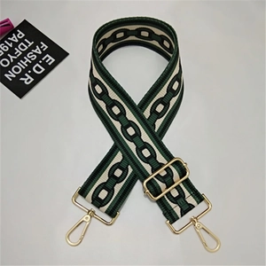 Detail of adjustable woven bag strap in cream and dark green with gold metal clasps