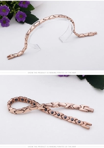 Detail of rose gold magnetic therapy bracelet with X-shaped links and black magnets
