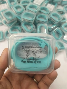 Detailed view of mint green silicone pedometer watch with school logo in retail packaging