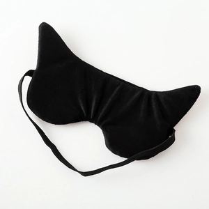 Close-up of black plush cat-ear sleep mask with soft texture and elastic headband