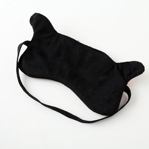 Detail of cute black plush cat ear sleep mask with soft texture and elastic strap