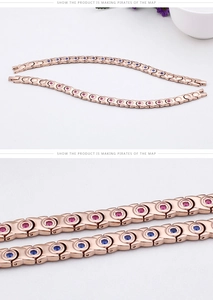 Detailed macro view of rose gold titanium bracelets with red and blue crystal inlay
