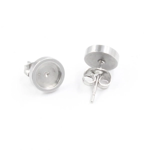 Detailed view of silver stainless steel round bezel stud earrings with butterfly backs