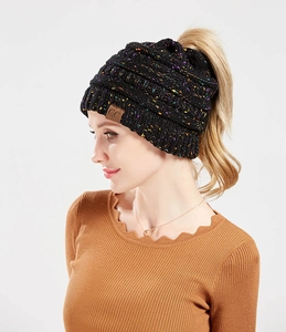 Detail of black knit beanie with colorful speckles, ponytail hole and CC leather patch
