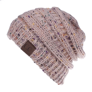 Close-up of beige confetti knit beanie with chunky yarn texture and brown C.C leather patch