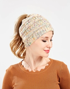 Detail of off-white knit ponytail beanie with colorful flecks and functional top opening