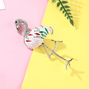 Detailed view of pink enamel flamingo brooch with rhinestones on colorful background