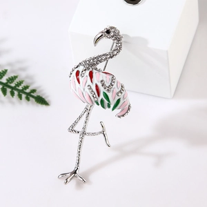 Detailed close-up of pink and green enamel flamingo brooch with sparkling crystals