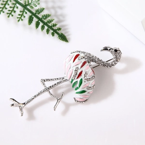 Detailed view of flamingo brooch with pink enamel and sparkling crystals on white background