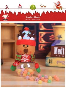 Close-up of reindeer plush lid on a transparent Christmas candy jar with festive sweets