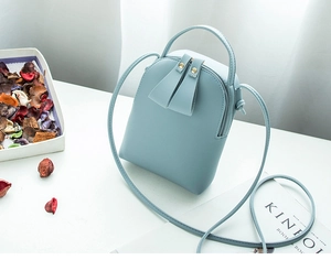Detail of light blue mini PU leather crossbody phone bag with handle and shoulder strap