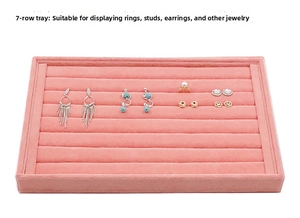 Detailed macro view of pink velvet 7-row jewelry tray displaying rings and earrings