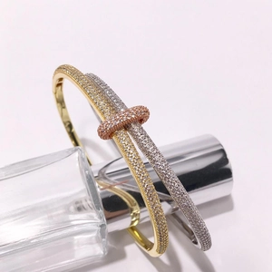 Detail of interlocking rhinestone bangles in gold, silver, and rose gold finish