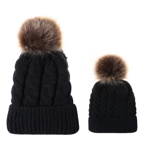 Parent-child cable knit beanie set in black with faux fur pom poms and warm winter lining