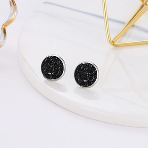 Macro detail of round black druzy earrings on white marble, 12mm stainless steel studs