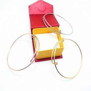 Close-up of adjustable gold, silver, and rose gold bangles in a gift box