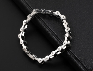 Detail of silver bicycle chain style stainless steel bracelet on black leather