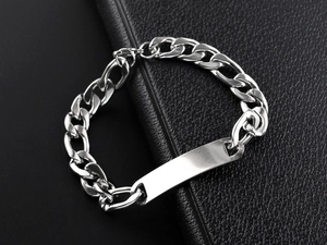 Detailed close-up of a silver stainless steel Cuban link bracelet with a blank metal plate