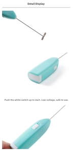 Detail of teal hand mixer showing push-slide switch and stainless steel spring whisk head