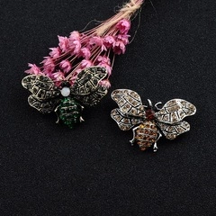 Detail view of vintage insect brooches with multicolored crystals on black padding