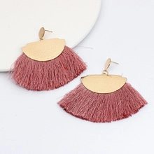 Détail de boucles d'oreilles à franges en métal doré et soie rose pourpre en éventail