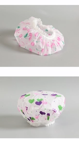 Détail de bonnets de douche imperméables avec motifs cerises roses et ballons coeurs