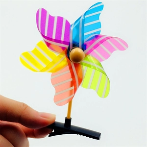 Close-up of colorful striped pinwheel hair clip with wooden bead on white background