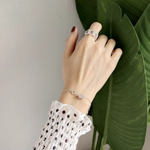 Close-up of S925 sterling silver bracelet and hollowed ring with rhinestones on hand