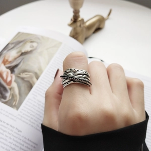 Detail of vintage layered 925 silver ring with hammered texture and black stones on finger