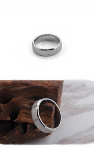 Macro detail of brushed titanium steel ring featuring vertical grooves and silver matte finish