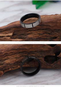 Detail showing two-tone titanium steel ring with brushed texture on wood background