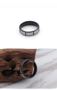 Detail of two-tone stainless steel ring with brushed silver finish and black grooves