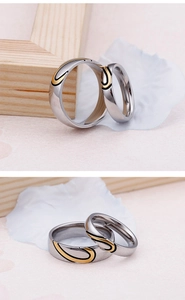 Detail view of interlocking heart design couple rings in polished silver and gold finish