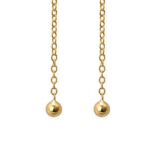 Detail of elegant gold chain earrings with polished ball charms on white background