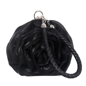 Detail of elegant black silk rose petals on evening clutch bag with woven handle